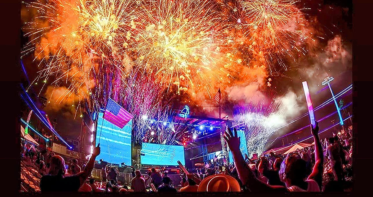 Fireworks over a concert stage and crowd